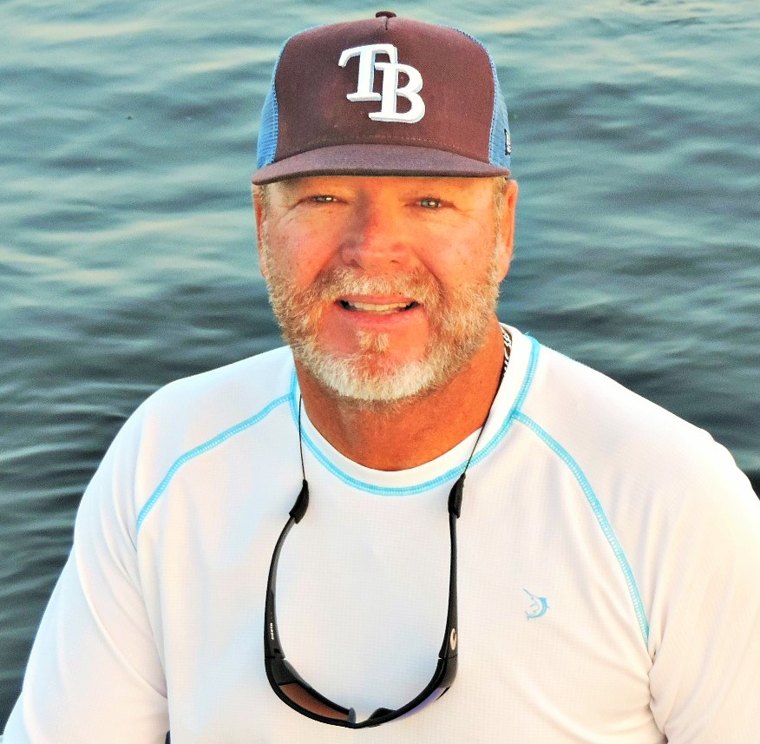 Chet Jennings, owner of Sun City Auto Buyers, smiling on the water